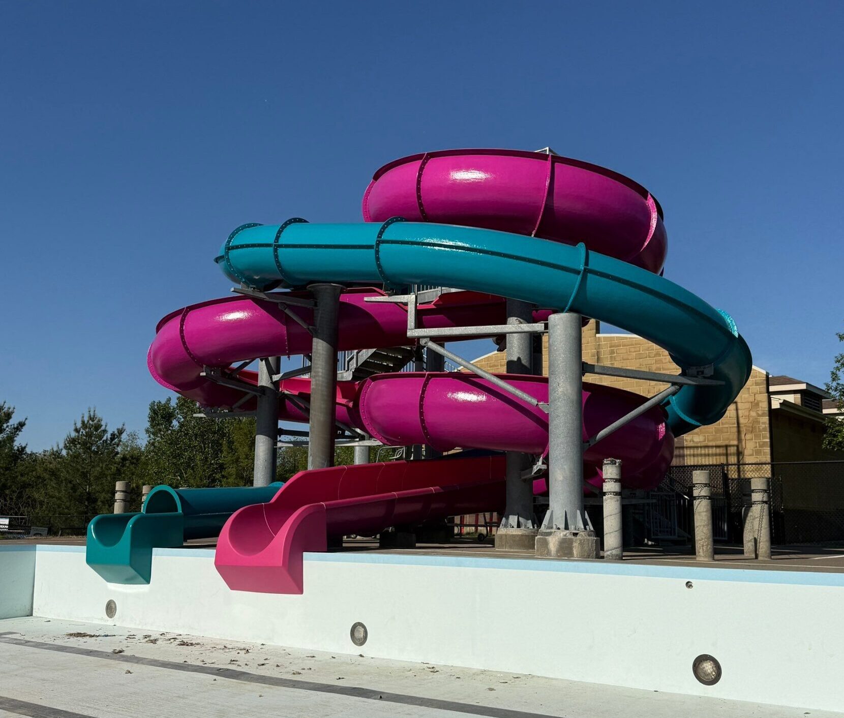 Magenta and teal waterslides after restoration at Pella Aquatic Center in Iowa.